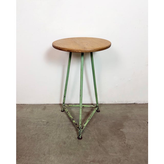 Vintage Industrial factory stool made in former Czechoslovakia during the 1960s It features a plywood seat and a green...