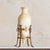 A tall French alabaster vase elevated within a gilt metal stand, likely dating to the early 20th century. Carved from...