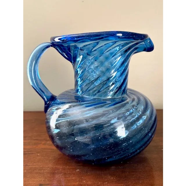 A beautiful blue hand blown glass pitcher with swirl pattern. No chip or cracks, this pitcher can also serve as a lovely...