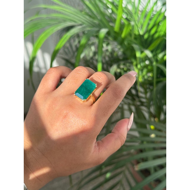 This statement cocktail ring features one bold emerald-cut natural green emerald weighing approximately 12.59 carats,...