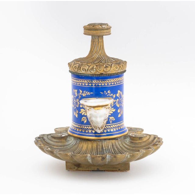 French Porcelain and Bronze Encrier a Pompe, the floral gilt decorated blue porcelain vessel mounted on shell form inkwell...