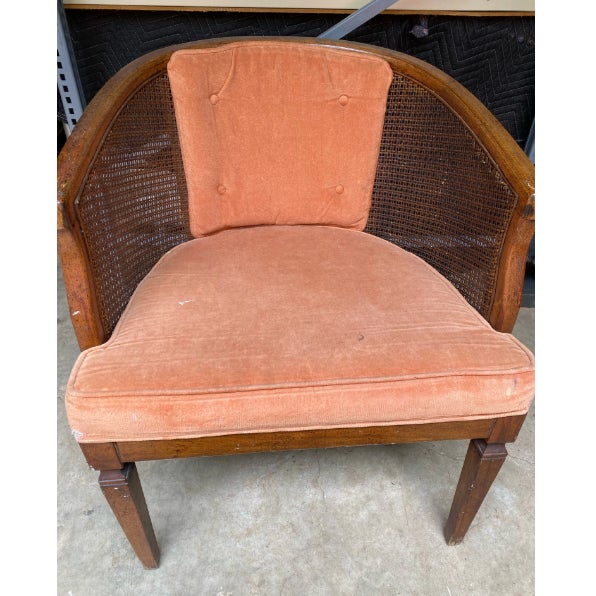 **Description:** Vintage barrel accent chair featuring elegant dusty rose upholstery, a woven cane back, and a gracefully...