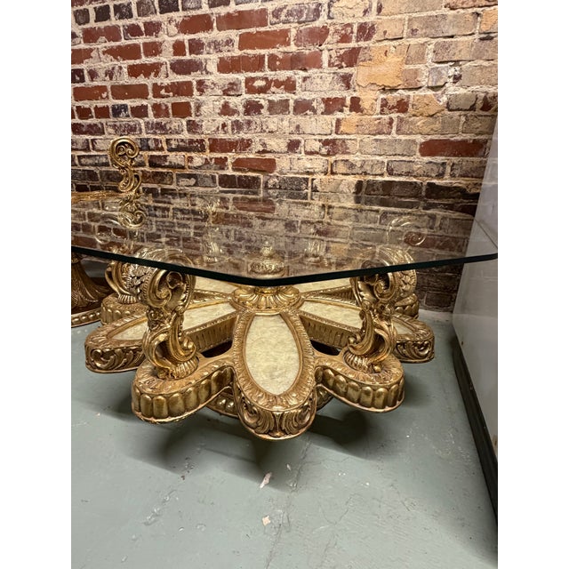 Hollywood Regency style coffee table, with a blossoming flower/sun burst design with mother-of-pearl. Octagonal glass top.