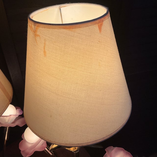 A sculptural pair of vintage Hollywood Regency table lamps featuring elegant dove forms rising among stylized blooming...