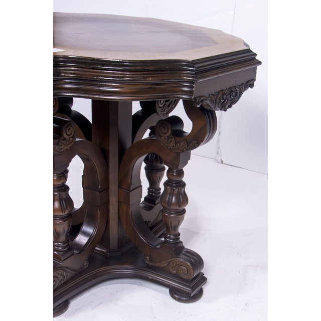 A richly sculptural Jacobean Revival oak center table, dating to the early 20th century, featuring a bold architectural...