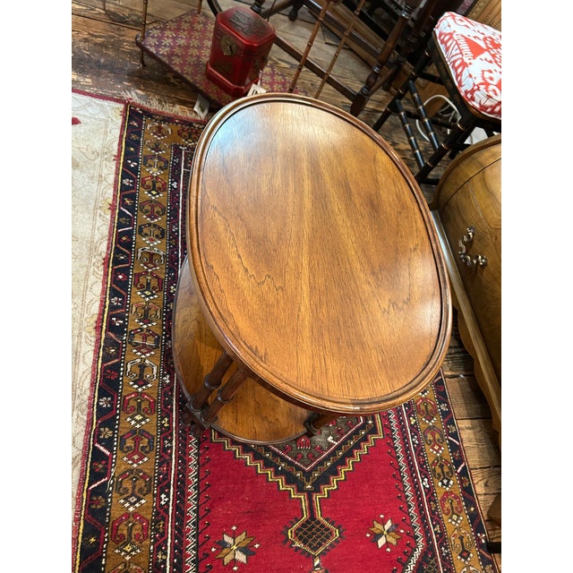 Handsome walnut two tier oval side table having turned legs and beautiful grain. CD