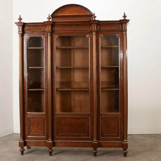 Dimensions: 96 ½” H x 71 ⅛” W x 18 ⅛” D A statement French bibliotheque in the Louis XVI style made of richly toned...