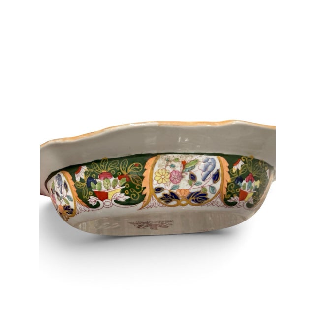 A beautifully decorative antique English ironstone serving bowl featuring an exuberant chinoiserie-inspired design of...