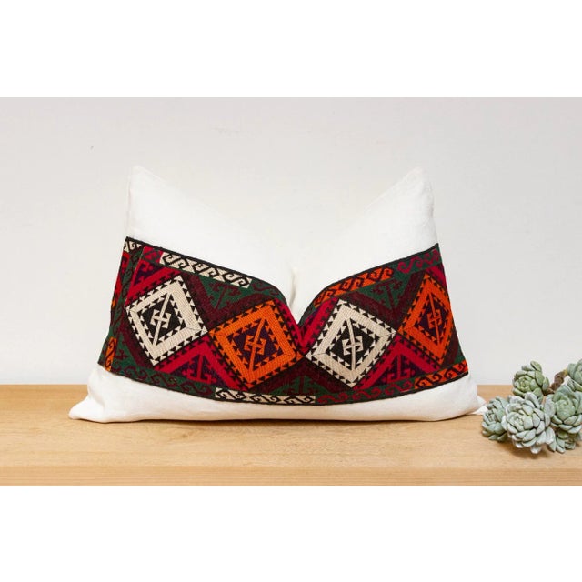 This handcrafted pillow features a vibrant, hand-stitched textile created by the Lakai tribe of Uzbekistan. It is a unique...