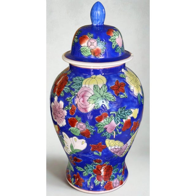 Presenting a colorful Chinese Ginger jar with floral, fruit and butterfly motifs on a true-blue background. Height with...