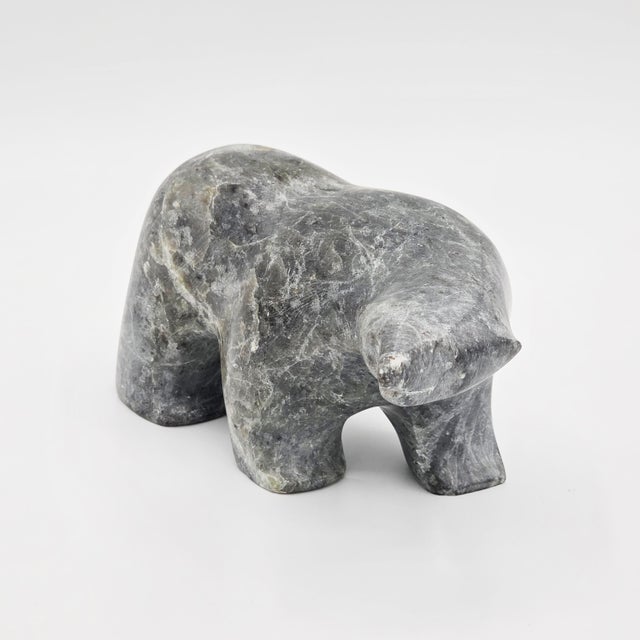 A signed carved stone bear sculpture by Ben Saclamana, an Inupiaq / Inuit artist associated with King Island, Alaska....