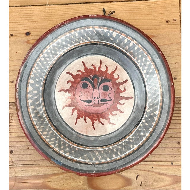 This vibrant vintage hand-painted ceramic plate features a captivating celestial sun motif, a classic symbol of vitality...