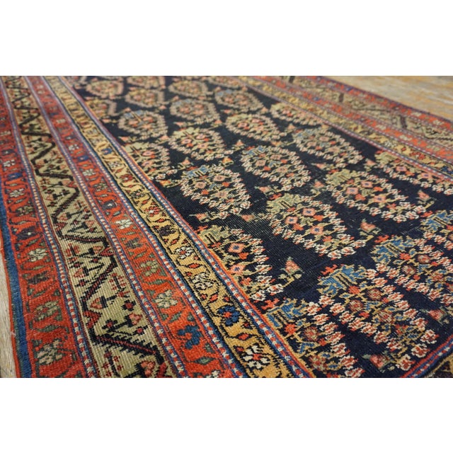 This Antique Persian Malayer Hallway Runner Rug, dating back to the 1900s, is a stunning example of village weaving from...
