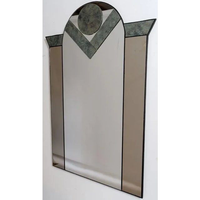 Postmodern, or Art Deco, form mirror, with geometric inserts of patinated bronze, and smoked mirror panels flanking the...