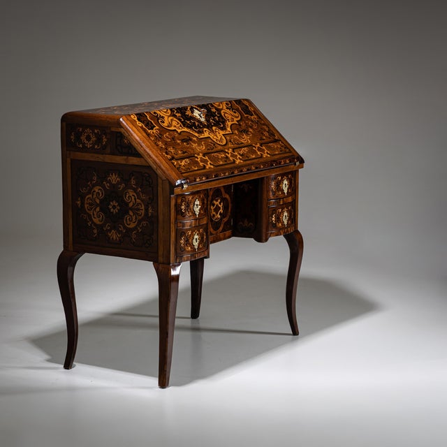 Small Baroque fall-front secretary on elegantly curved S-shaped legs, featuring four drawers and a central cabinet door....