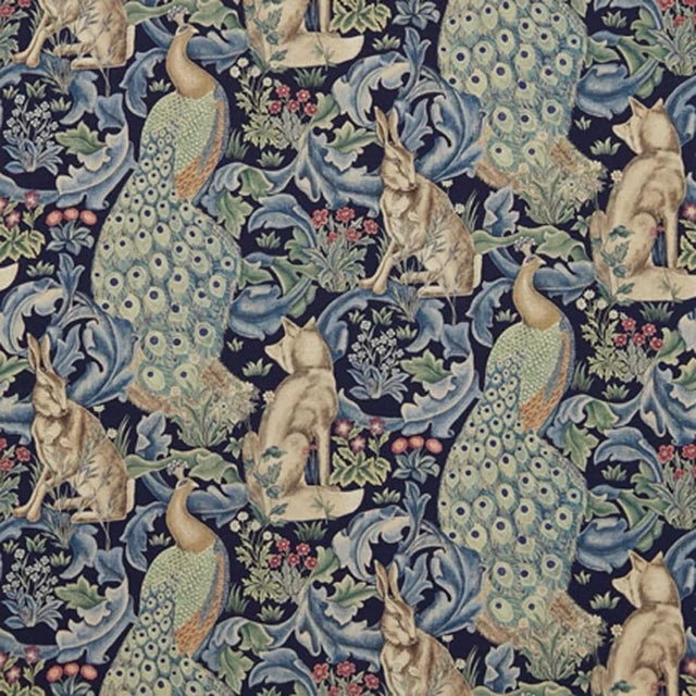 This printed fabric depicts scrolling acanthus leaves peacocks hares and foxes amongst bunches of wild flowers inspired by...