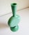 Stunning Art Deco vase in a vibrant mint green blown glass. Features graceful curves and a black ball accent at the base....