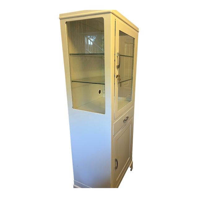 Circa 1950 vintage free standing metal and glass medicine/pharmacy cabinet. Original glass shelving and metal...