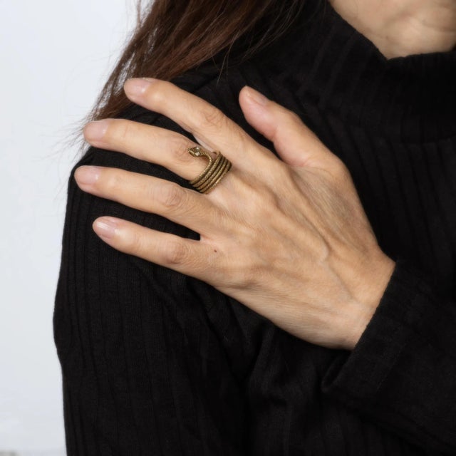 Finely detailed vintage snake ring crafted in 18 karat yellow gold (circa 1970s to 1980s). Two small single cut diamonds...