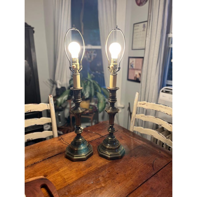 A classic pair of vintage c. 1970s solid brass candlestick-style table lamps manufactured by Westwood Industries Inc....