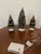 3 small mid 20 th c bottlebrush Holiday trees. The large one with battery operated flickering lights.