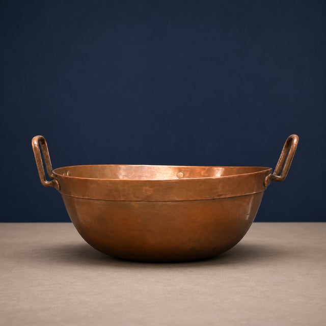 This 19th-century French copper confiture pan features a broad, rounded basin with a reinforced rim and tall loop handles...