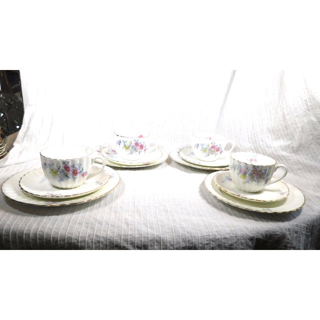 This is, maybe, a set of four fluted floral luncheon plates plus four saucers and four teacups. None of them are marked...