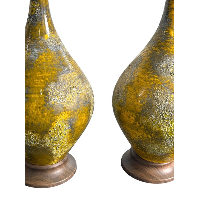 Mid century 1960s lava glazed lamps. Ceramic lamps with a mustard glaze with a lava rock style design. Walnut wood with a...