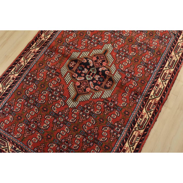 An authentic vintage tribal Hamedan rug hand-knotted with fine wool and natural dyes. This nomadic rug features a central...