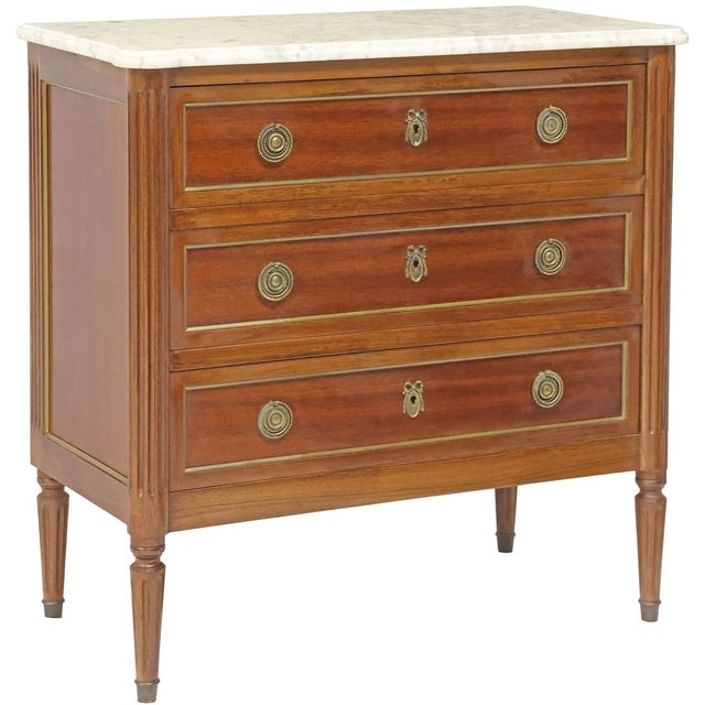 French Louis XVI style mahogany petite commode, early 20th c., having shaped marble top, over three drawers, with gilt-...