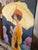 Impressionistic oil painting of a vintage woman with a yellow umbrella on a bright sunny day with flowers surrounding her.