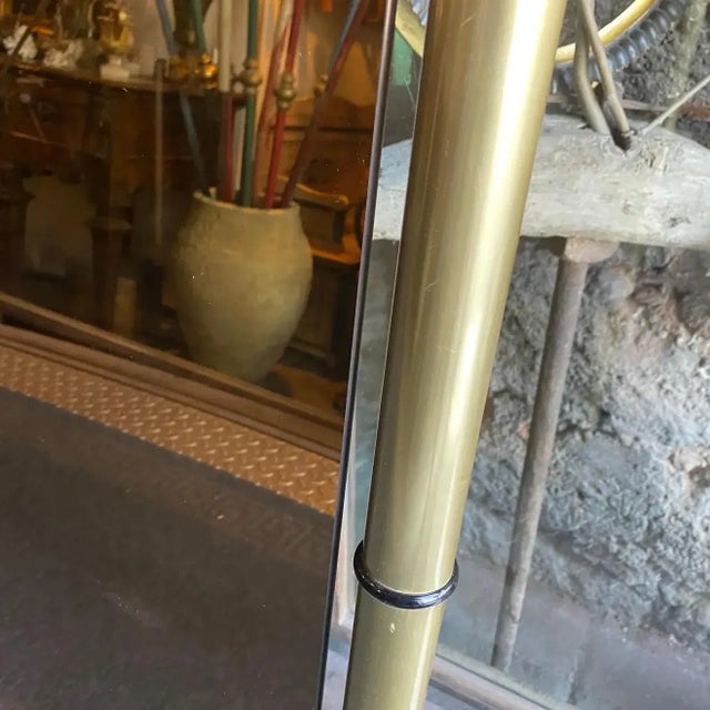 An high quality solid brass and pink glass wall mirror designed and manufactured in Italy in the Seventies by Cristal...