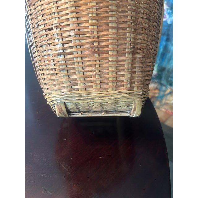 Handwoven split bamboo basket with vertical rib supports and a ventilated open band near the rim. The rectangular base and...