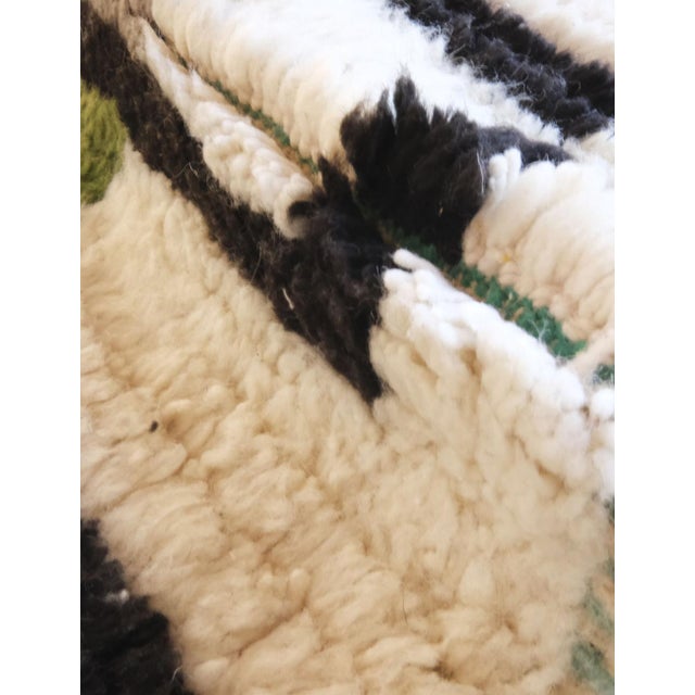 Contemporary Moroccan Runner Rug – Graphic Lines in Black, Ivory & Moss Green This contemporary Moroccan runner rug is a...