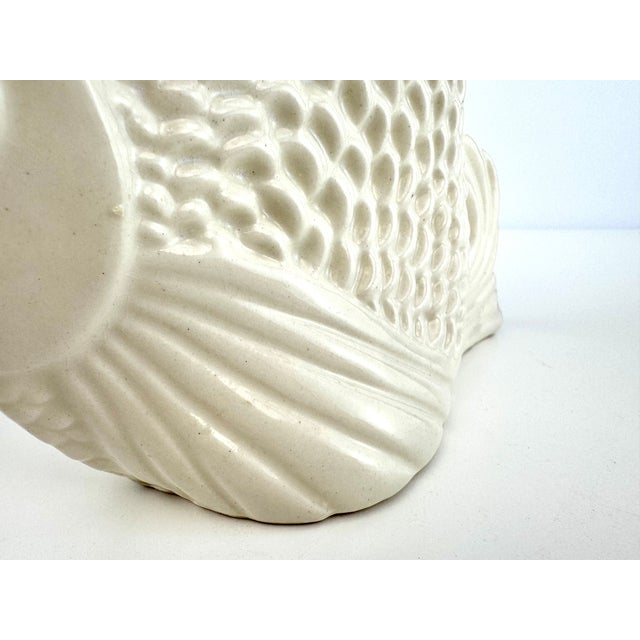 A striking mid-century Japanese ceramic vase modeled as a sculptural angelfish, finished entirely in a warm ivory-white...
