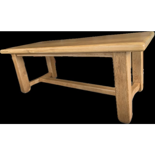 A unique, solid table crafted entirely from solid oak, characterized by its sturdiness, classic style, and the...