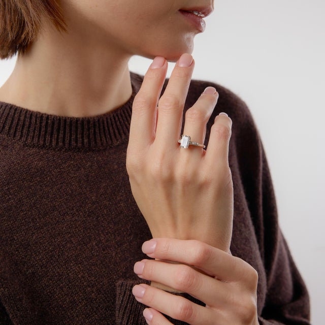 This exceptional Mid Century engagement ring is the epitome of refined elegance and timeless sophistication. At its center...