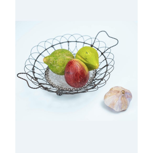 A wonderfully airy antique wire basket with twisted side handles and a hand-formed openwork body. Pieces like this were...