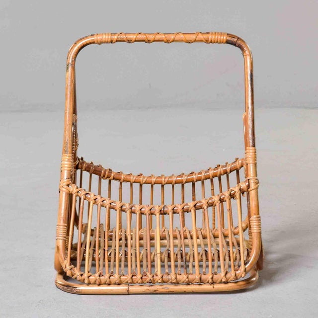 This Italian mid-century magazine basket is a distinctive example of the bamboo and rattan work associated with Franco...