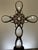 This one-of-a-kind assemblage sculpture pairs a softly tinted pink glass bottle with a handcrafted cross composed of...