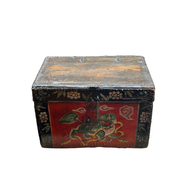 This vintage Chinese trunk features a vibrant, hand-painted Guardian Lion (Foo Dog) rendered in shades of emerald green...