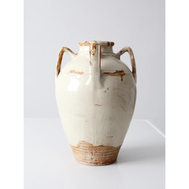 This vintage handmade studio pottery vase features a sculptural Mediterranean amphora form with four loop handles, a...
