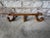 Vintage wall hanging coat rack, early American. Made of wood and brass, this piece has three (3) adjustable hooks that are...