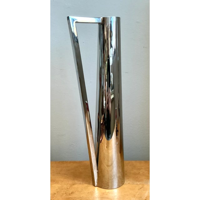 This vintage modernist metal pitcher captures the sleek minimalism of mid-20th-century design, its elongated cylindrical...
