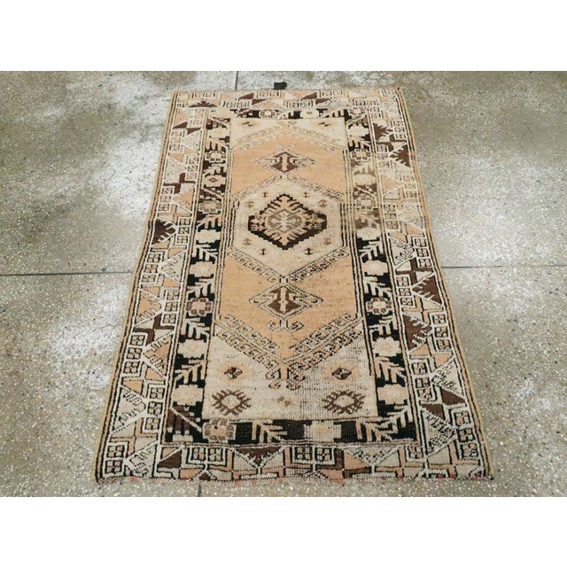 This mid-20th century Turkish Ghourdes rug, measuring 2' 10" x 4' 6", features a vertically aligned medallion composition...