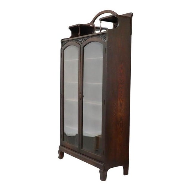 An antique Arts & Crafts period two-door bookcase, crafted from oak around 1910. The bookcase features a distinctive...