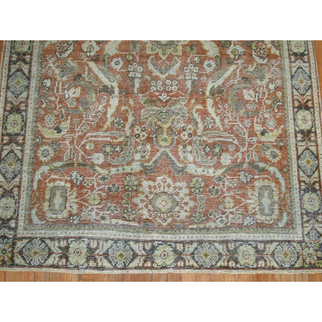 An early 20th century Persian Mahal weather appeal shabby chic rug in rustic tones. The field is terracotta, the border is...