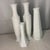 A charming collection of vintage mid-century white milk glass bud vases featuring classic fluted, hobnail, and diamond-...