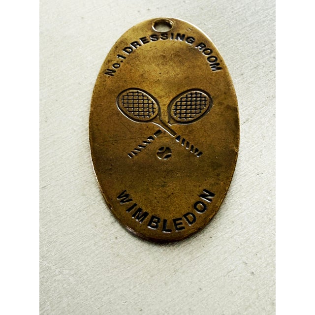 An extraordinary piece of tennis history — a RARE vintage brass key fob from the No. 1 Dressing Room at Wimbledon. Oval...
