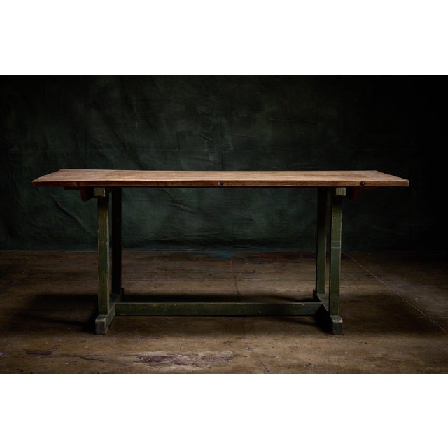 Vintage French work table in a trestle form with a thick oak plank top and green-painted base. The rustic farmhouse look...